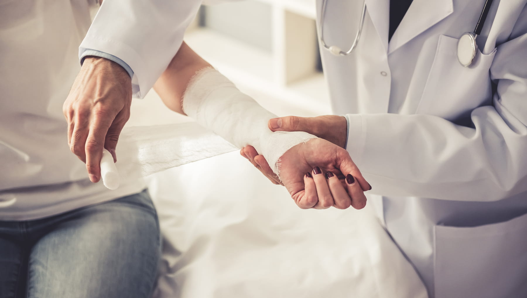 doctor applying a bandage to patient's wrist