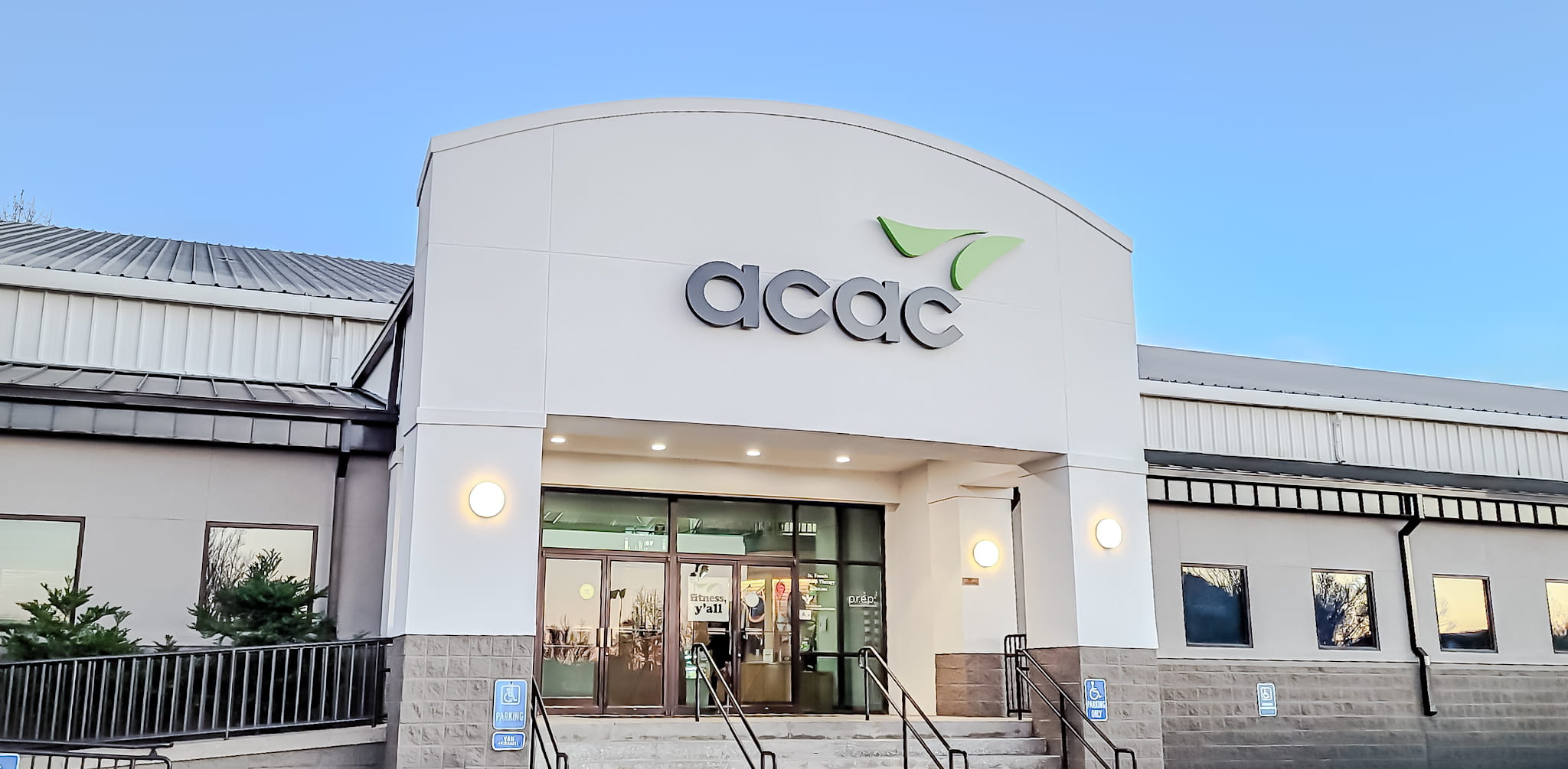 photo of the entrance to the acac facility. Shows accessibility ramp and stairs in front of glass doors.