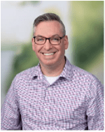 Aric Anderson. Appearing male, wearing a light-colored patterned shirt. Glasses