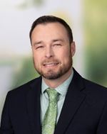 Joshua Crawford. Male wearing a suite with green shirt and green tie.