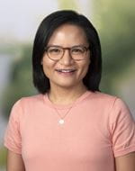 Thuy Tran Headshot - woman with dark hair in pink tee-shirt.